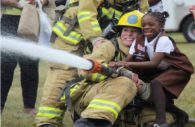 A possible future firefighter learns the basics of handling a fire hose, while also experiencing the thrill of managing the power of water.