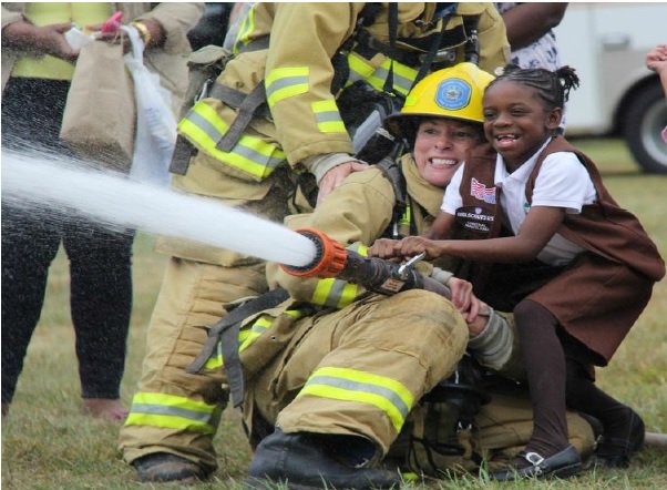 A possible future firefighter learns the basics of handling a fire hose, while also experiencing the thrill of managing the power of water.