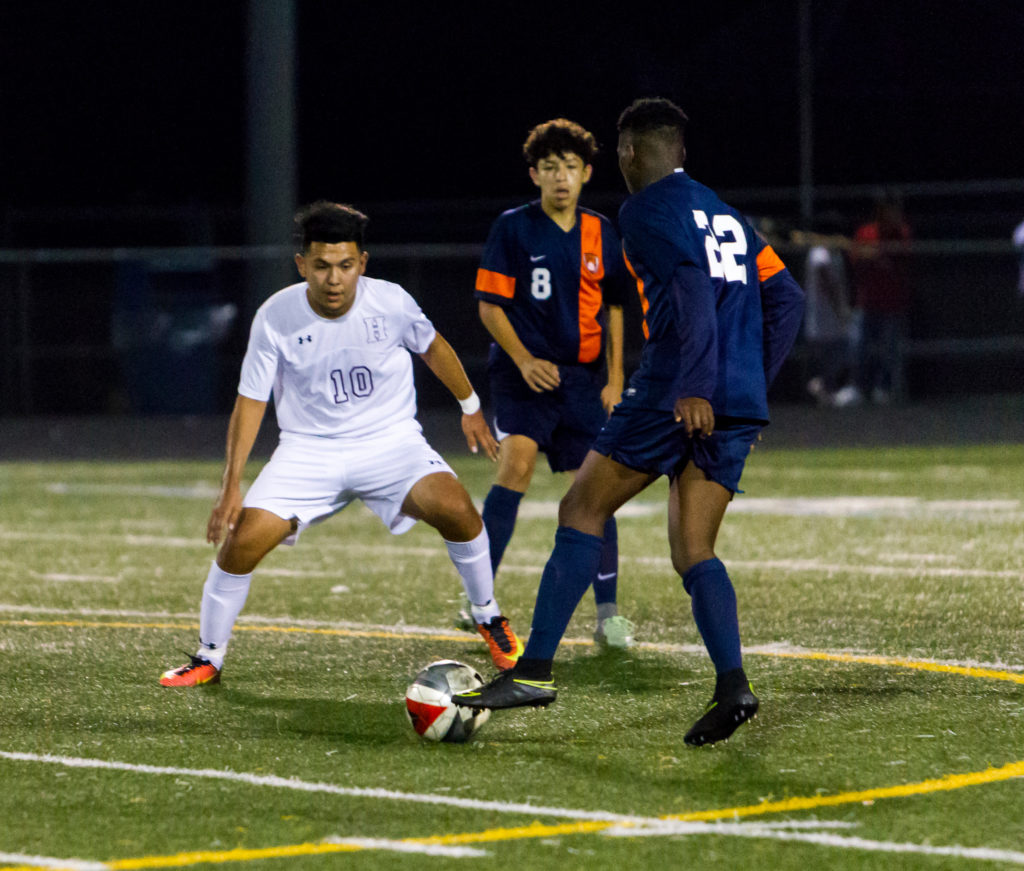 Hammond Golden Bear soccer forward Anthony Perez defends against Reservoir forward Kyree Akinkuowo while RHS midfielder Rudy Ventura watches during Reservoir’s 2-1 win Friday at Hammond High School. Perez scored the only goal for the Golden Bears. Photo by YANAIR PHOTOGRAPHY. 