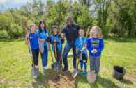 Students from Dayton Oaks Elementary School take a moment to pose with County Executive Calvin Ball before Ball and students plant first tree at Arbor Day event.